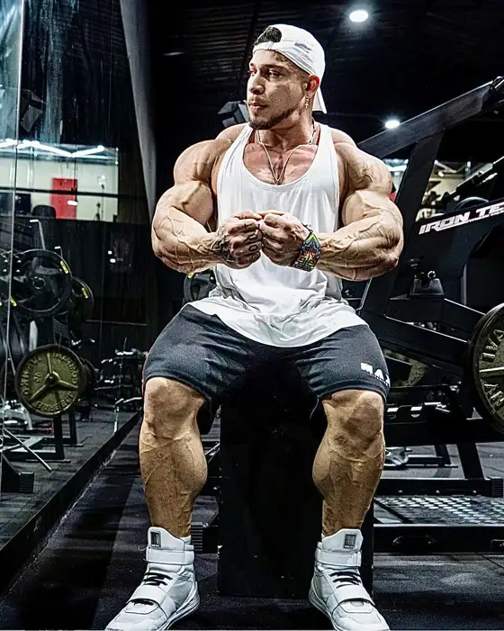 Atleta sentado na academia usando botas Iron Training brancas