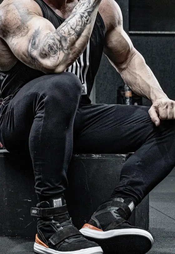 Atleta usando a bota Iron Training preta e laranja na academia